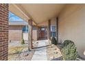Inviting home entrance with a decorative door, a brick pillar and well maintained landscaping at 1843 S Pierson Ct, Lakewood, CO 80232