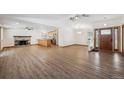Open-concept living room featuring hardwood floors, a fireplace, and a view of the kitchen and front door at 1843 S Pierson Ct, Lakewood, CO 80232