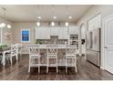 Bright kitchen featuring white cabinets, stainless steel appliances, and a large center island with bar seating at 3242 Waterfront Dr, Monument, CO 80132