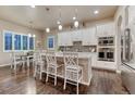 Bright kitchen featuring a large island, white cabinets, granite countertops, and stainless steel appliances at 3242 Waterfront Dr, Monument, CO 80132