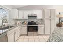 Well-lit kitchen boasting granite counters, stainless steel appliances, and sleek white cabinets at 1838 Wilson Cir, Erie, CO 80516