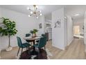 Charming dining area features a modern chandelier, brick wall and adjacent access to the kitchen at 1060 S Parker Rd # 36, Denver, CO 80231