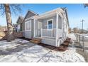 Charming bungalow with gray siding, white porch, and well-maintained landscaping at 3500 N Marion St, Denver, CO 80205