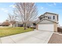 Charming gray two-story home with a well-maintained lawn and long driveway in a residential neighborhood at 5426 Bobcat St, Frederick, CO 80504