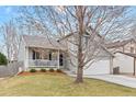 Charming gray two-story home with a front porch and well-maintained lawn in a residential neighborhood at 5426 Bobcat St, Frederick, CO 80504