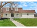 Charming two-story home with a landscaped yard, featuring a well-maintained lawn and walkway at 6325 W Portland Pl, Littleton, CO 80128