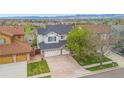 Attractive two-story home with a well-maintained lawn, mature landscaping, and convenient three-car attached garage at 6614 W Gould Dr, Littleton, CO 80123