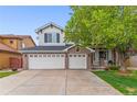 Two-story home with a brick front, three-car garage, and mature shade tree in the front yard at 6614 W Gould Dr, Littleton, CO 80123