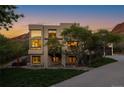 A modern home with a well-manicured lawn and a long driveway, complemented by a backdrop of unique rock formations at 5668 Red Fern Ct, Littleton, CO 80125