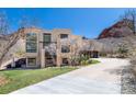 Modern two-story home with a long driveway surrounded by a mountain backdrop at 5668 Red Fern Ct, Littleton, CO 80125