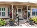 Welcoming front porch with brick accents, decorative plants, and seating, perfect for relaxing outdoors at 7682 S Cove Cir, Centennial, CO 80122