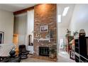 Spacious living room with a striking brick fireplace, vaulted ceilings, and ample natural light at 7682 S Cove Cir, Centennial, CO 80122