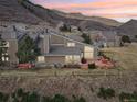 A view of the rear exterior showing the deck, hot tub, fenced yard, and surrounding natural hillside at 6960 Buckskin Dr # 86, Littleton, CO 80125