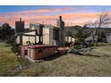 A view of the exterior with the hot tub on a wooden deck at dusk, showing the exterior and landscaping at 6960 Buckskin Dr # 86, Littleton, CO 80125
