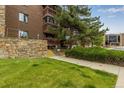 Close-up of condo's brick exterior, showcasing a stone wall and a landscaped walkway at 12565 Sheridan Blvd # 105, Broomfield, CO 80020
