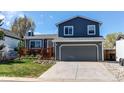 Two-story home with a gray exterior, attached garage, and a front yard with a wood deck at 8463 Wheatgrass Cir, Parker, CO 80134