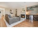 Inviting living room with cozy fireplace, wood floors, and stylish wood shelving and mini fridge at 5573 S Lowell Blvd, Littleton, CO 80123