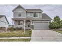 Charming two-story home featuring a well-manicured lawn, stone accents, and an attached two-car garage at 8695 Torrey St, Arvada, CO 80007