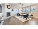 Cozy living room featuring a tiled fireplace, ceiling fan, and hardwood flooring with contemporary furnishings at 8695 Torrey St, Arvada, CO 80007