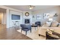 Cozy living room featuring a tiled fireplace, ceiling fan, and hardwood flooring with contemporary furnishings at 8695 Torrey St, Arvada, CO 80007