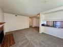 Spacious living area showcasing an open layout with fireplace and a view into the kitchen area at 12470 E Cornell Ave # 203, Aurora, CO 80014
