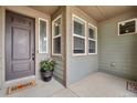 Cozy covered front porch with a stylish door, charming accents, and a welcoming atmosphere at 19409 W 88Th Dr, Arvada, CO 80007