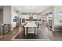 Bright, open kitchen features white cabinets, stainless steel appliances and a spacious island with seating at 19409 W 88Th Dr, Arvada, CO 80007