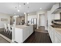 Kitchen with island, seating, stainless steel appliances, and tile backsplash at 19409 W 88Th Dr, Arvada, CO 80007