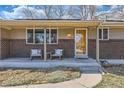 Inviting front porch with chairs and a view of the home's exterior details at 1255 S Hoyt St, Lakewood, CO 80232