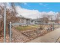 Single-story home with fenced yard and garden, showcasing the property's curb appeal at 117 6Th St, Frederick, CO 80530
