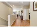 Open hallway with hardwood floors, neutral tones, and seamless transition to living spaces at 8272 E 55Th Pl, Denver, CO 80238