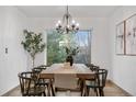 Elegant dining room with a chandelier, large window, and a rustic wooden table at 8164 S York Ct, Centennial, CO 80122