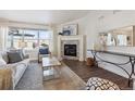 Living room featuring a cozy corner fireplace and large windows at 22586 E Union Cir, Aurora, CO 80015