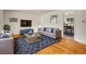 Comfortable living room featuring hardwood floors, a modern sofa, and stylish decor at 7881 Kenwood St, Commerce City, CO 80022