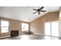 Bright living room featuring vaulted ceilings, a fireplace, hardwood floors, and sliding glass doors at 18950 E Kent Cir, Aurora, CO 80013