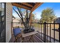 Cozy balcony with wooden furniture and black metal railing, perfect for outdoor relaxing at 6011 Yarrow St # C, Arvada, CO 80004