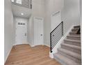 Bright foyer with wood floors, a staircase with iron railing, and a front door with glass panels at 6880 S Yantley Ct, Aurora, CO 80016