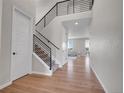 Bright foyer with hardwood floors, a staircase with iron railings, and views into the living area at 6880 S Yantley Ct, Aurora, CO 80016