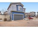 Two-story home with blue siding, attached garage and brick paver driveway at 17950 E 54Th Ave, Denver, CO 80249