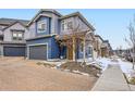 Charming two-story home features blue siding, a covered porch, and an attached garage at 17950 E 54Th Ave, Denver, CO 80249