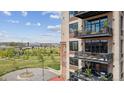 A close up of a multi-story building featuring balconies with outdoor furniture, overlooking a lush park at 2000 Little Raven St # 4A, Denver, CO 80202
