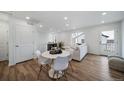 Bright living room boasts wood floors, lots of natural light, modern decor, and an adjacent dining area at 13543 E 103Rd Ave, Commerce City, CO 80022