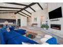 Spacious living room featuring vaulted ceilings, exposed beams, and a cozy fireplace with TV at 10179 E 59Th North Pl, Denver, CO 80238