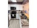 Well-lit kitchen with stainless steel appliances, white cabinets, and durable counter tops at 8224 Washington St # 11, Denver, CO 80229