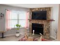 Cozy living room boasts stone fireplace, large window and hardwood floors at 8224 Washington St # 11, Denver, CO 80229