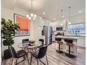 Bright eat-in kitchen with stainless steel appliances, island seating, and modern light fixtures at 12920 Jasmine St # F, Thornton, CO 80602