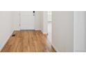 Bright entryway with light wood-look flooring and fresh white paint, inviting you into the home at 45933 Wood Thrush Ave, Bennett, CO 80102