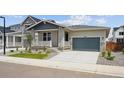 View of home with two-car garage, stone accents, neutral siding, and a small landscaped front yard at 45933 Wood Thrush Ave, Bennett, CO 80102