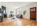 Bright living room featuring hardwood floors, a stone fireplace, and ample natural light from large windows at 1909 S Logan St, Denver, CO 80210