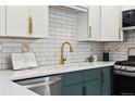 Stylish kitchen boasts white subway tile backsplash, quartz countertops, and gold hardware at 1227 Yost St, Aurora, CO 80011